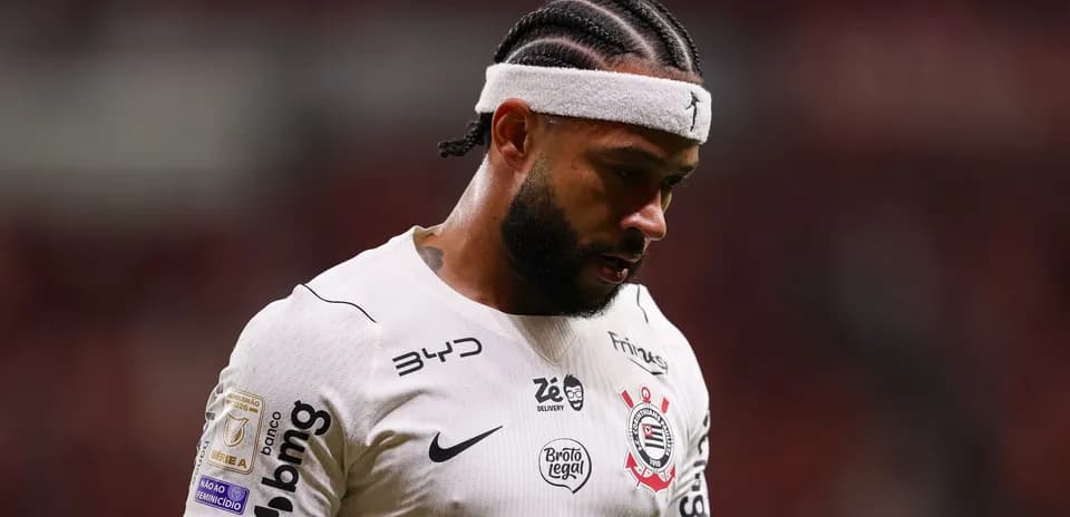 Jugador de fútbol con camiseta blanca mirando hacia abajo