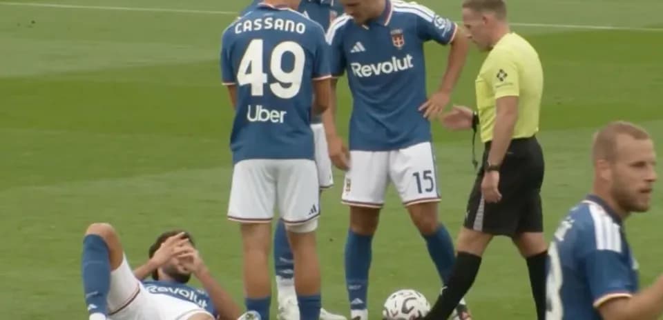 Jugadores de fútbol rodeando a un compañero caído
