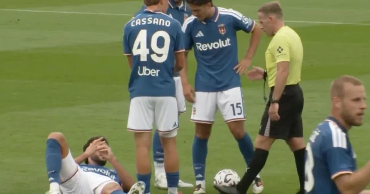 Jugadores de fútbol rodeando a un compañero caído
