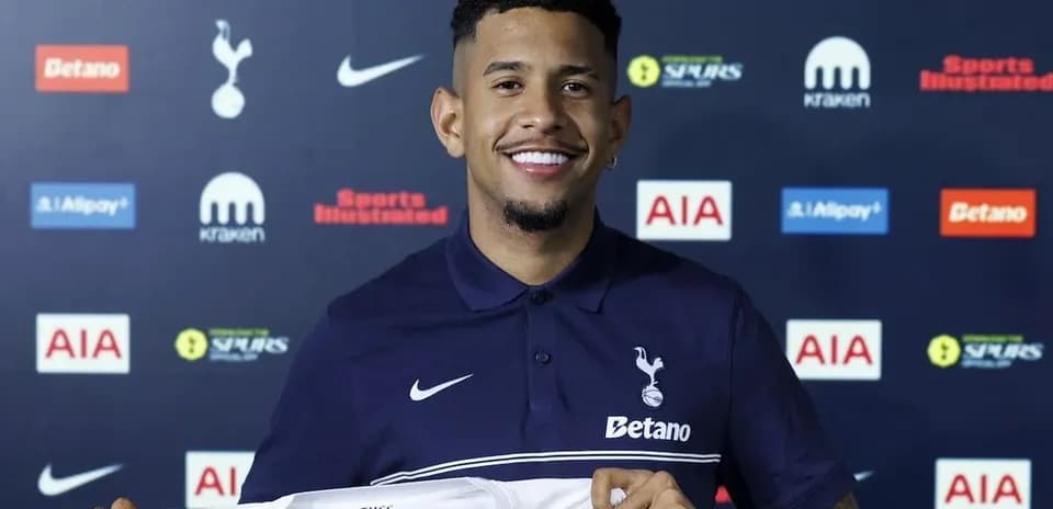 Jugador sosteniendo camiseta de Tottenham Hotspur en conferencia
