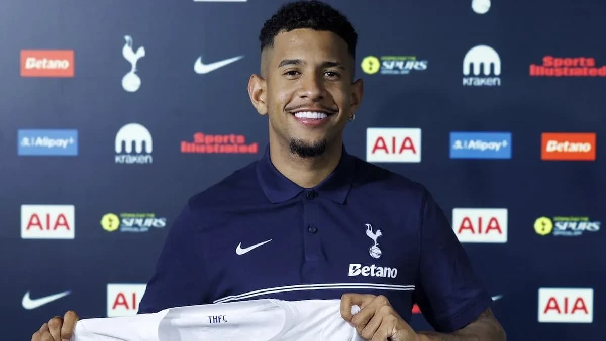 Jugador sosteniendo camiseta de Tottenham Hotspur en conferencia