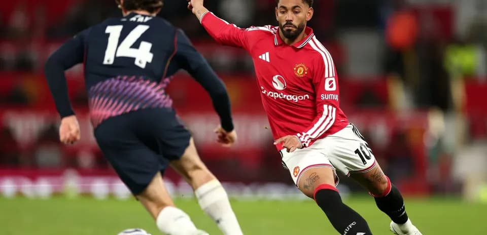 Jugador de Manchester United persiguiendo el balón en partido