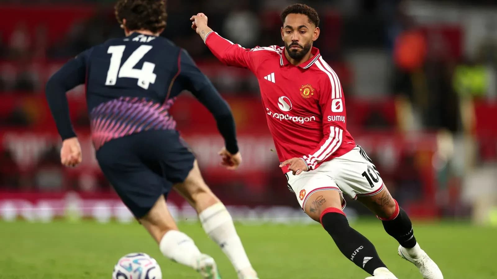 Jugador de Manchester United persiguiendo el balón en partido