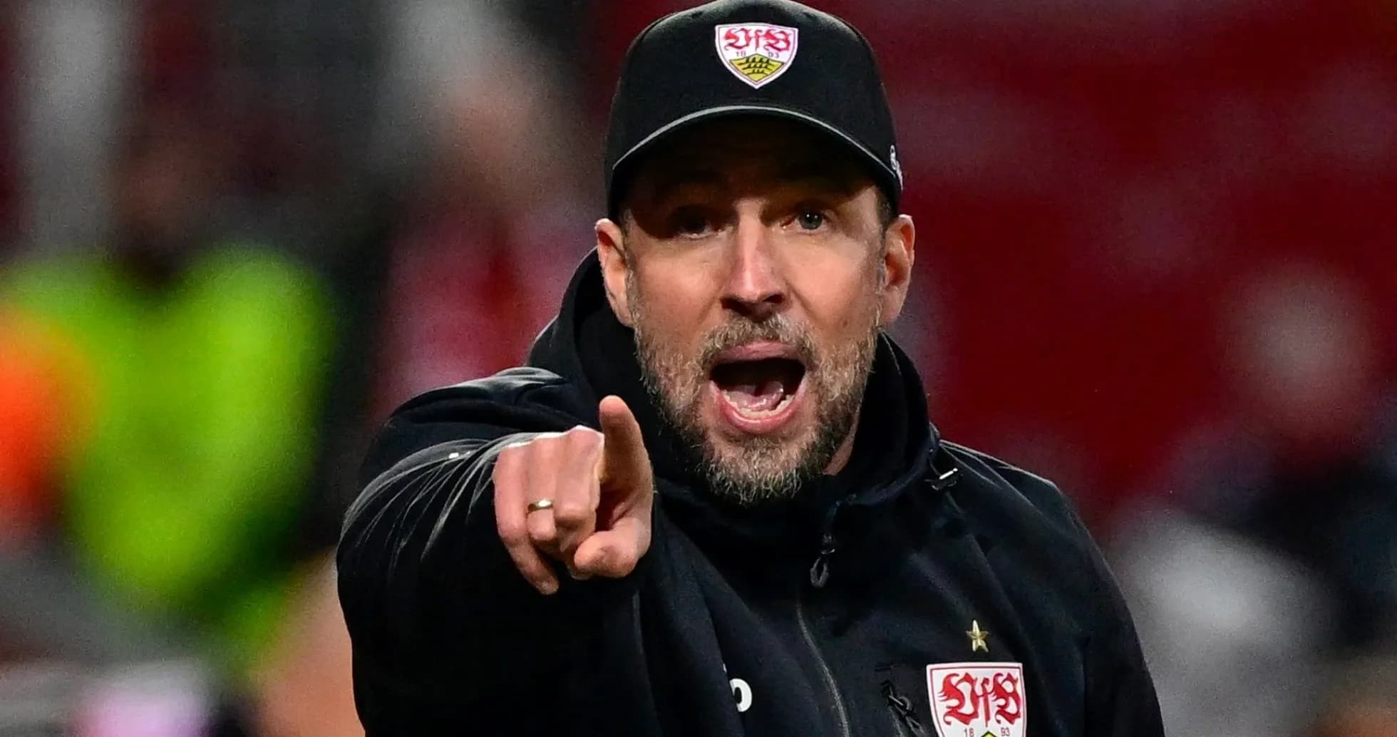 Entrenador señalando durante un partido en estadio