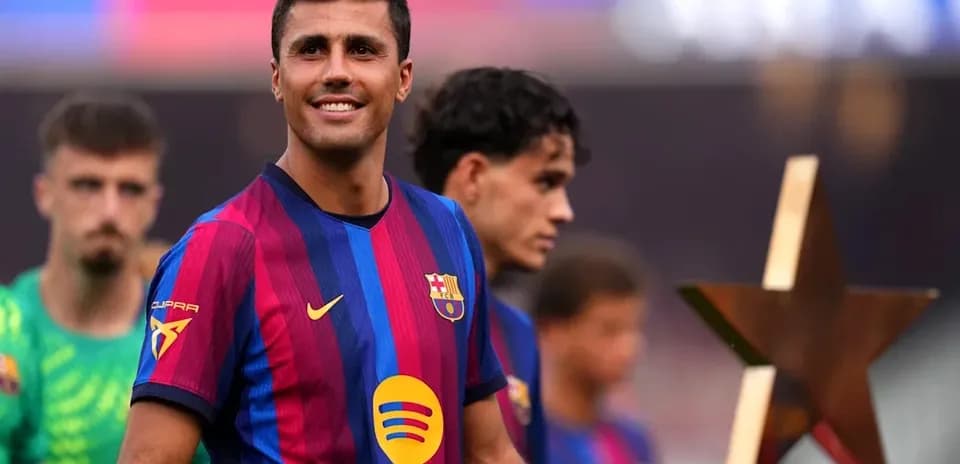 Jugador de Barcelona sonriendo con compañeros detrás