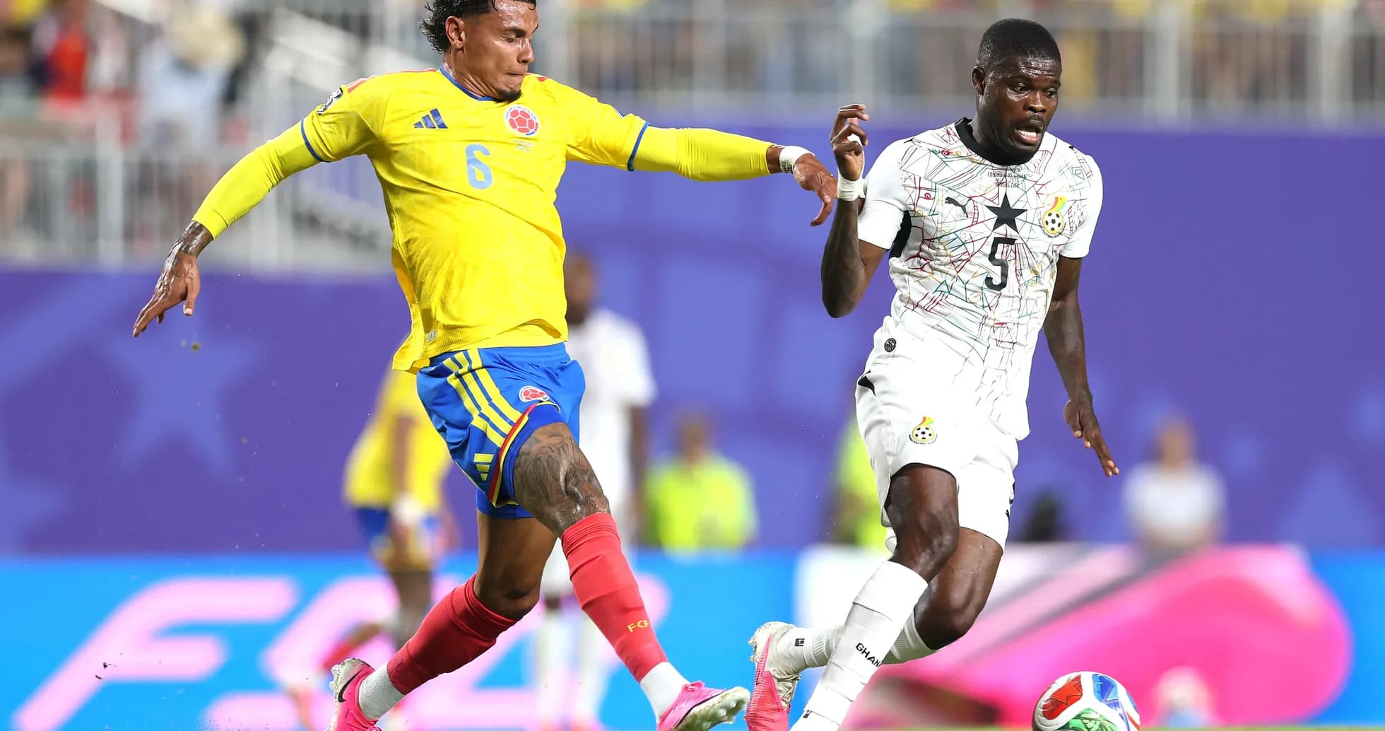 Jugador colombiano persiguiendo a jugador ghanés