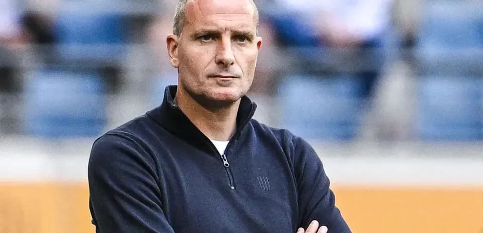 Entrenador con brazos cruzados en el banquillo