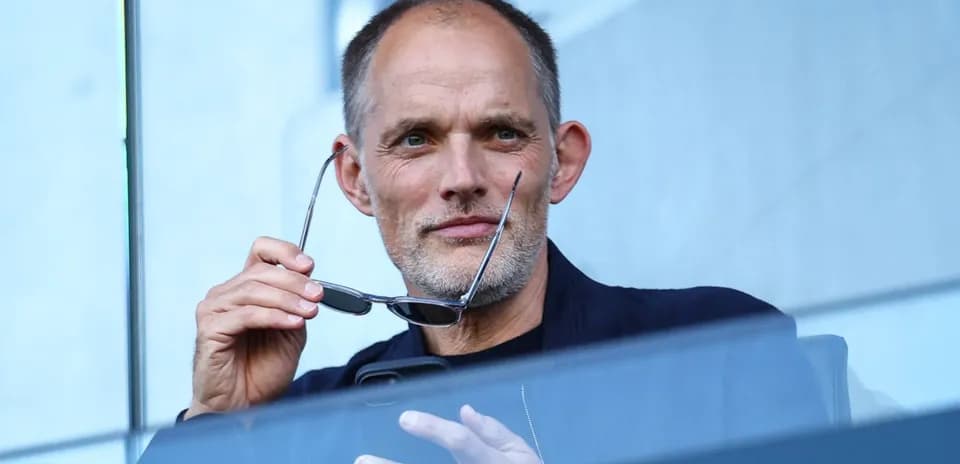 Hombre sosteniendo gafas en un palco de estadio