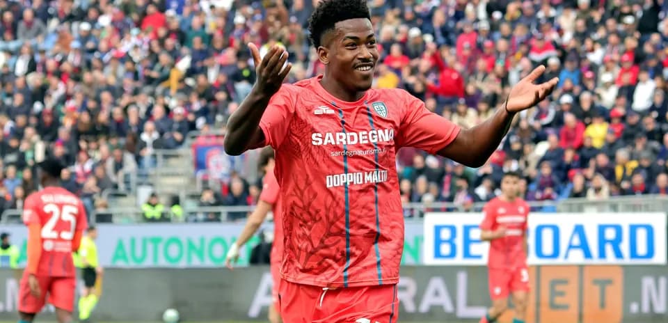 Jugador celebrando en partido con afición de fondo