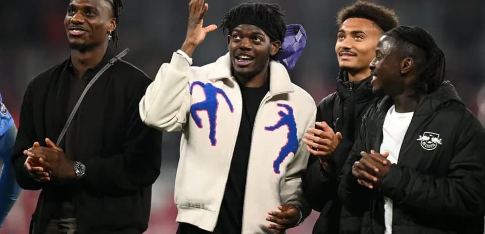 Cuatro jugadores sonriendo y aplaudiendo en el campo