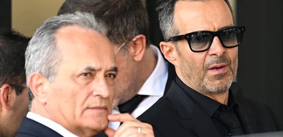 Dos hombres conversando en un evento formal