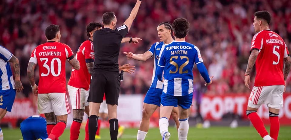 Árbitro mostrando tarjeta amarilla a jugador durante partido