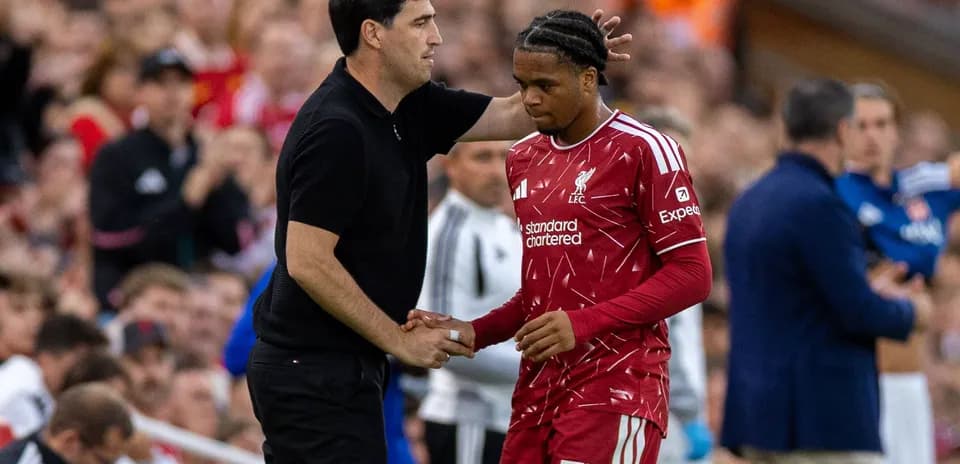 Entrenador hablando con jugador en el banquillo
