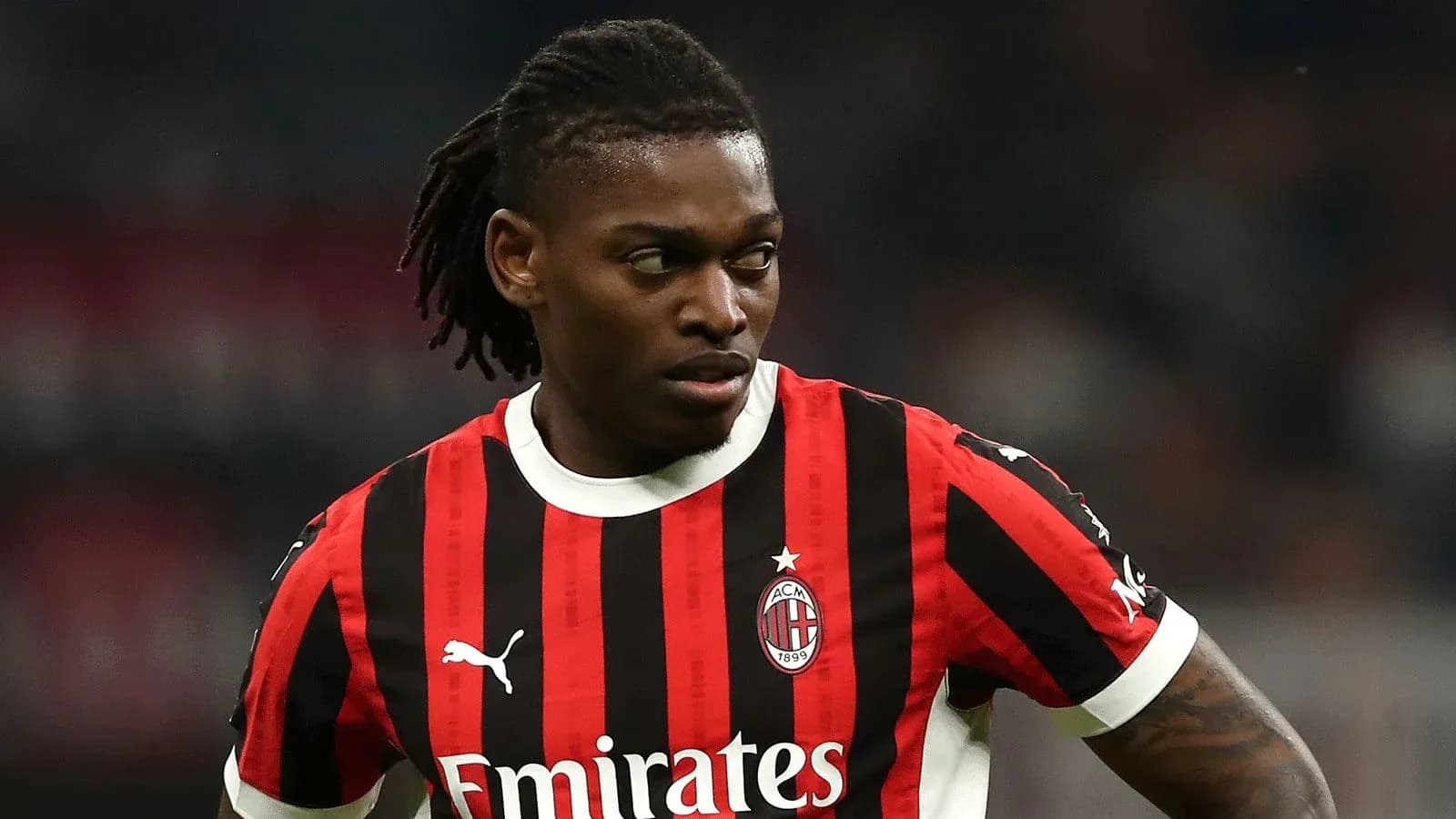Jugador de AC Milan con camiseta a rayas rojas y negras