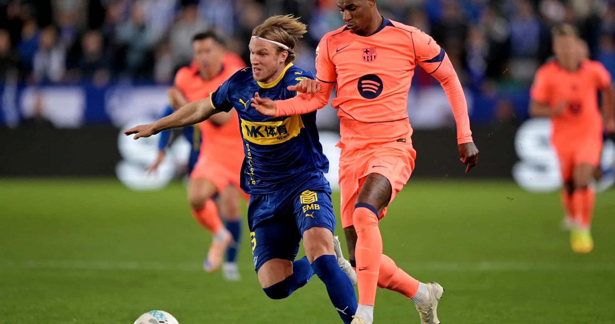 Jugador de Alavés siendo tackleado por jugador de Barcelona
