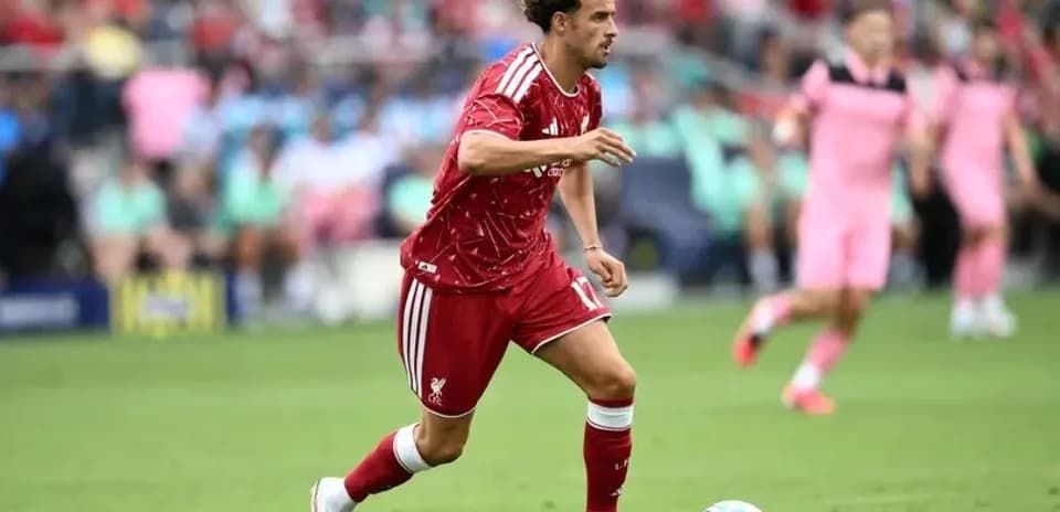 Jugador de Liverpool avanzando con el balón en el campo