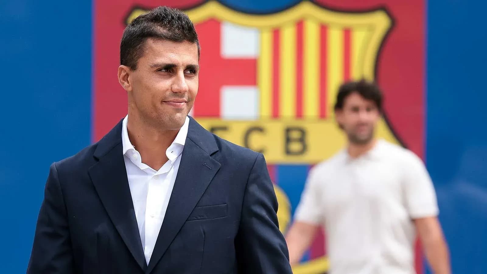 Jugador posando frente al escudo del FC Barcelona