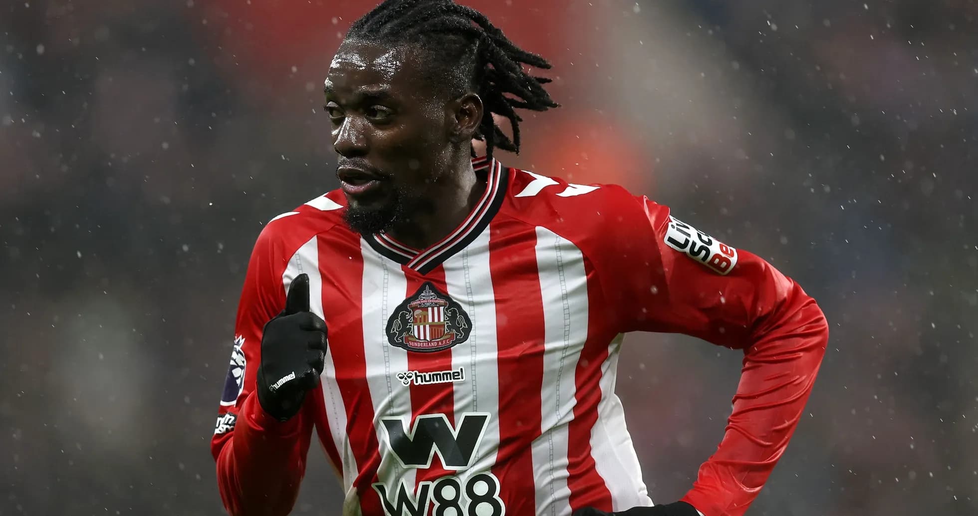 Jugador de Sunderland corriendo en partido bajo la lluvia