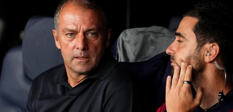 Entrenador y asistente conversando en el banquillo
