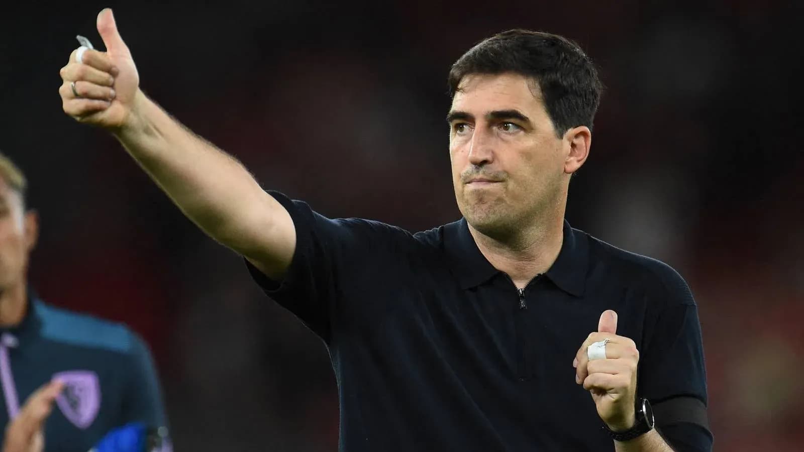 Entrenador dando un pulgar arriba en el partido