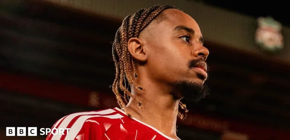 Jugador con trenzas en uniforme rojo en el estadio