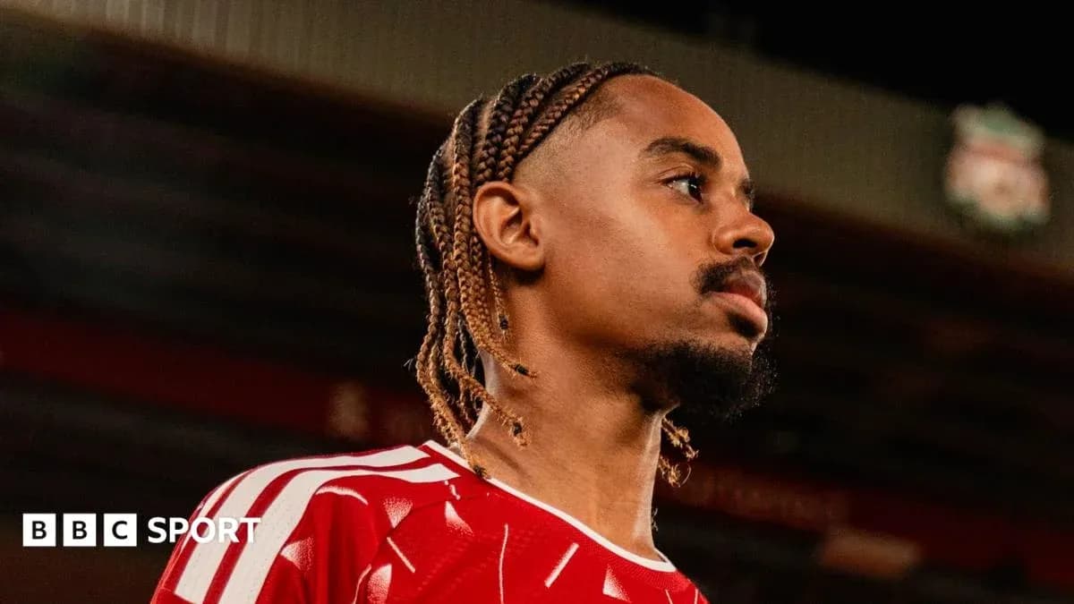 Jugador con trenzas en uniforme rojo en el estadio