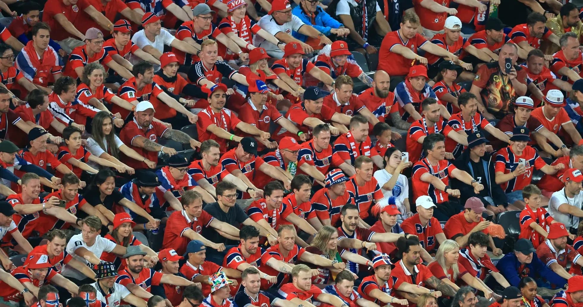 Aficionados animando en el estadio con camisetas rojas