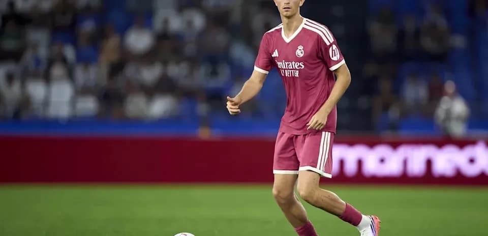 Jugador de Real Madrid controlando el balón en el campo