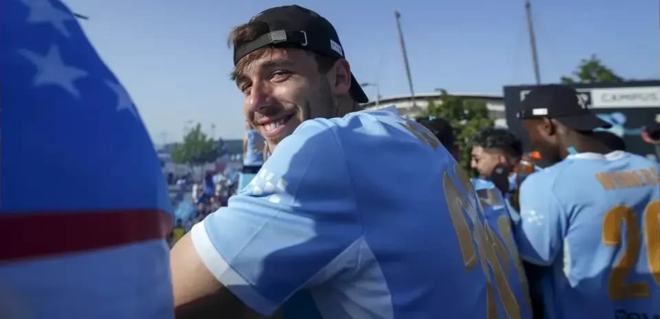 Jugador sonriente en celebración con compañeros de equipo