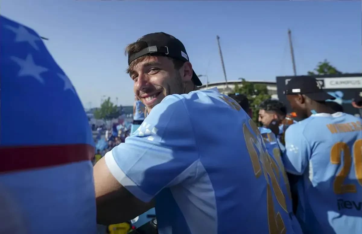 Jugador sonriente en celebración con compañeros de equipo
