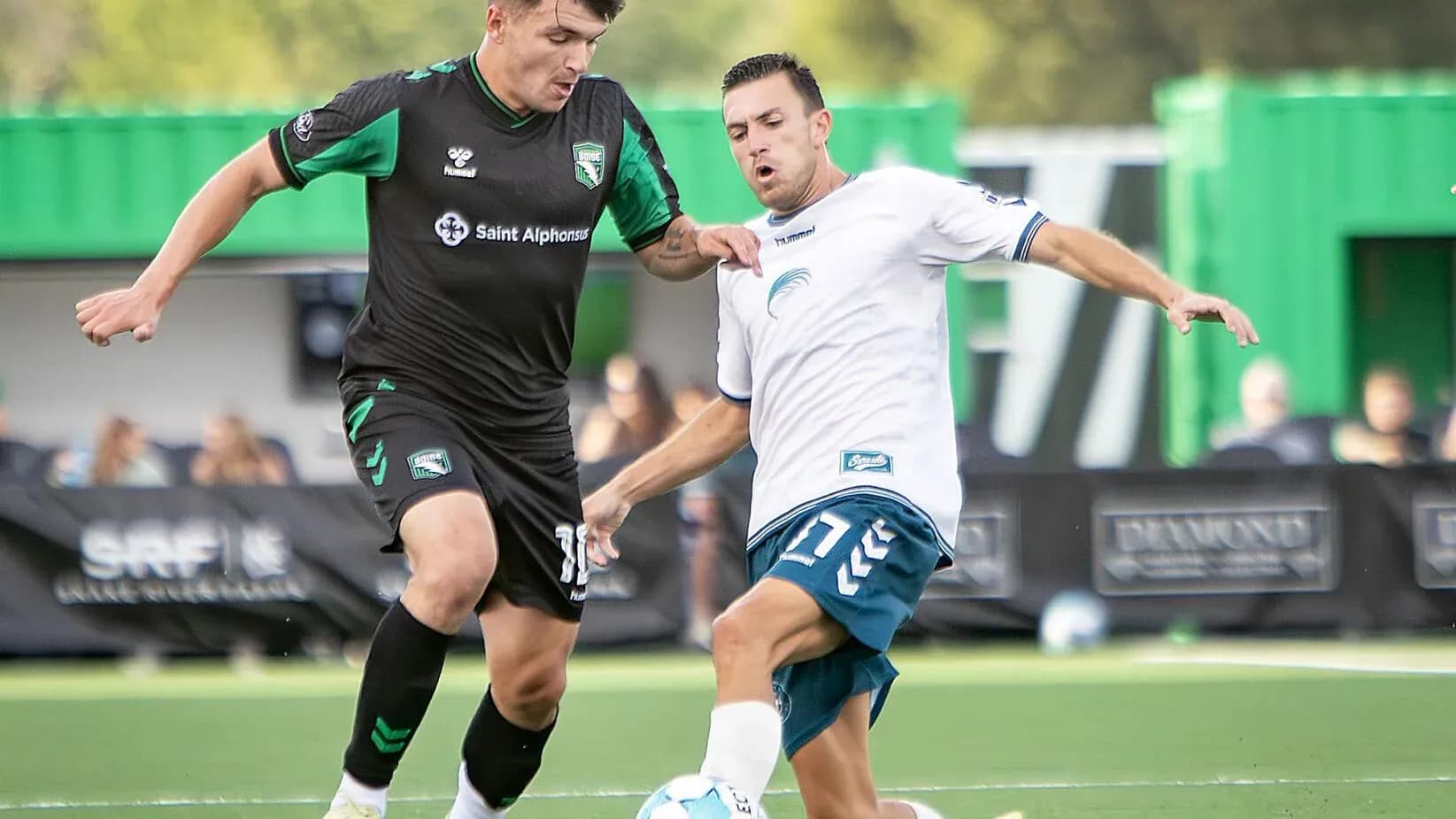 Dos jugadores compitiendo por el balón en el partido