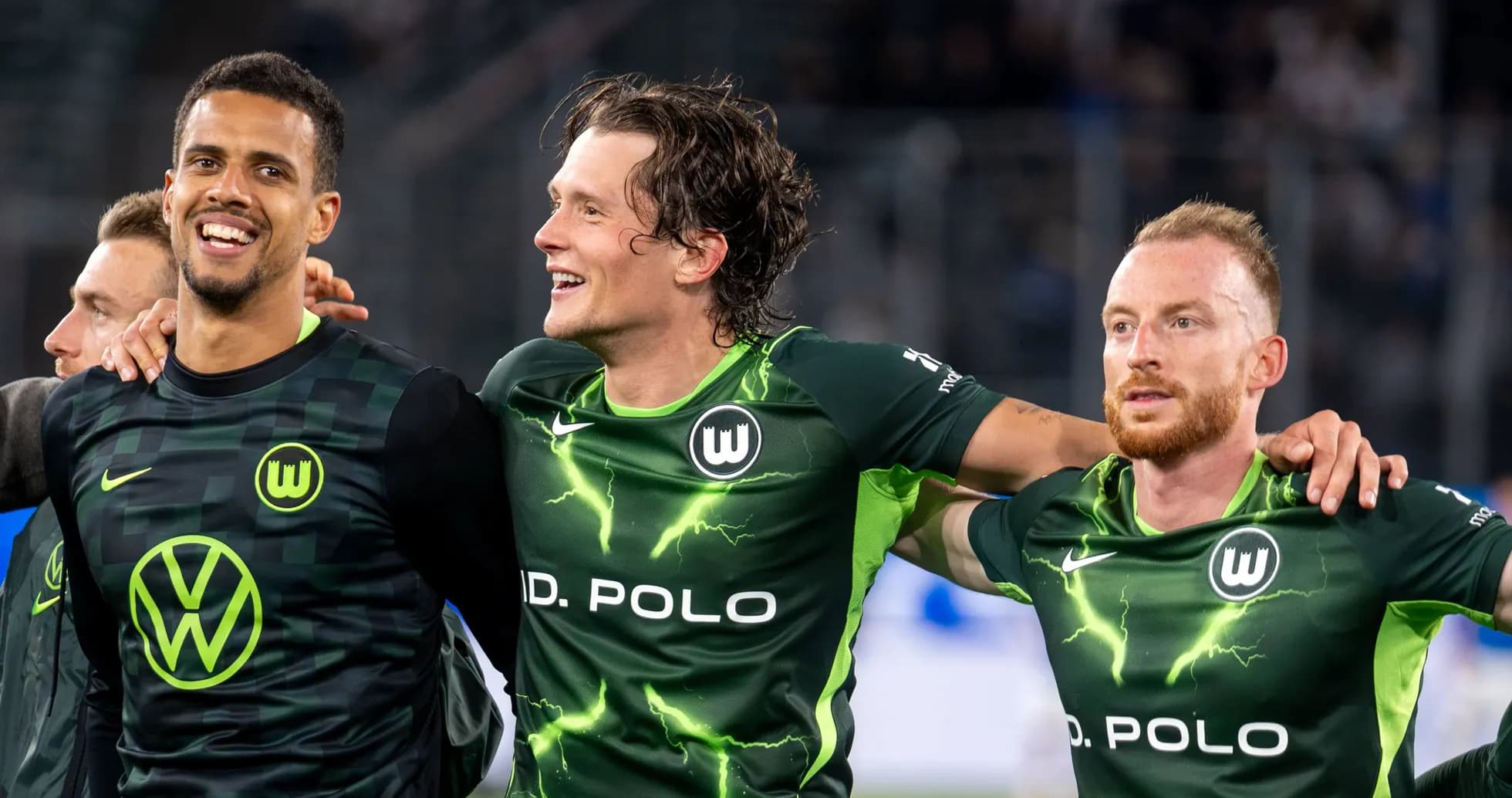 Jugadores de VfL Wolfsburg celebrando juntos en el campo
