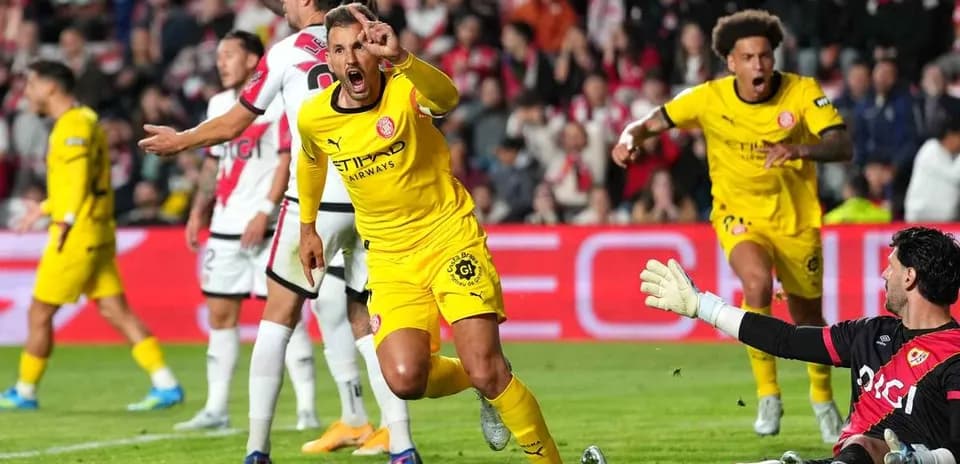 Jugador celebrando un gol mientras el portero observa