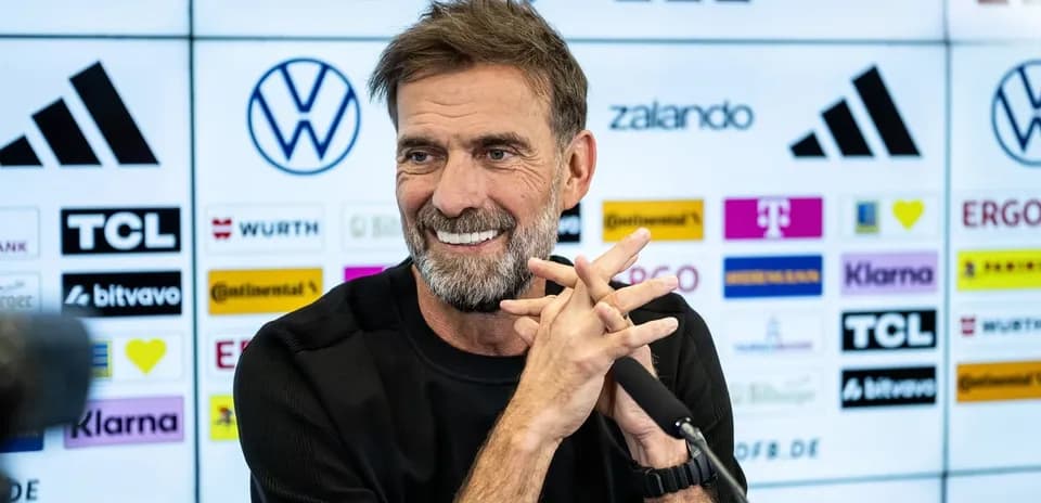 Entrenador en conferencia de prensa sonriendo