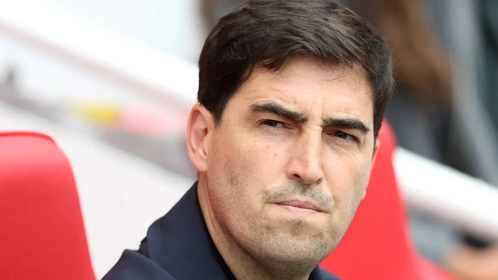 Entrenador observando el partido desde el banquillo