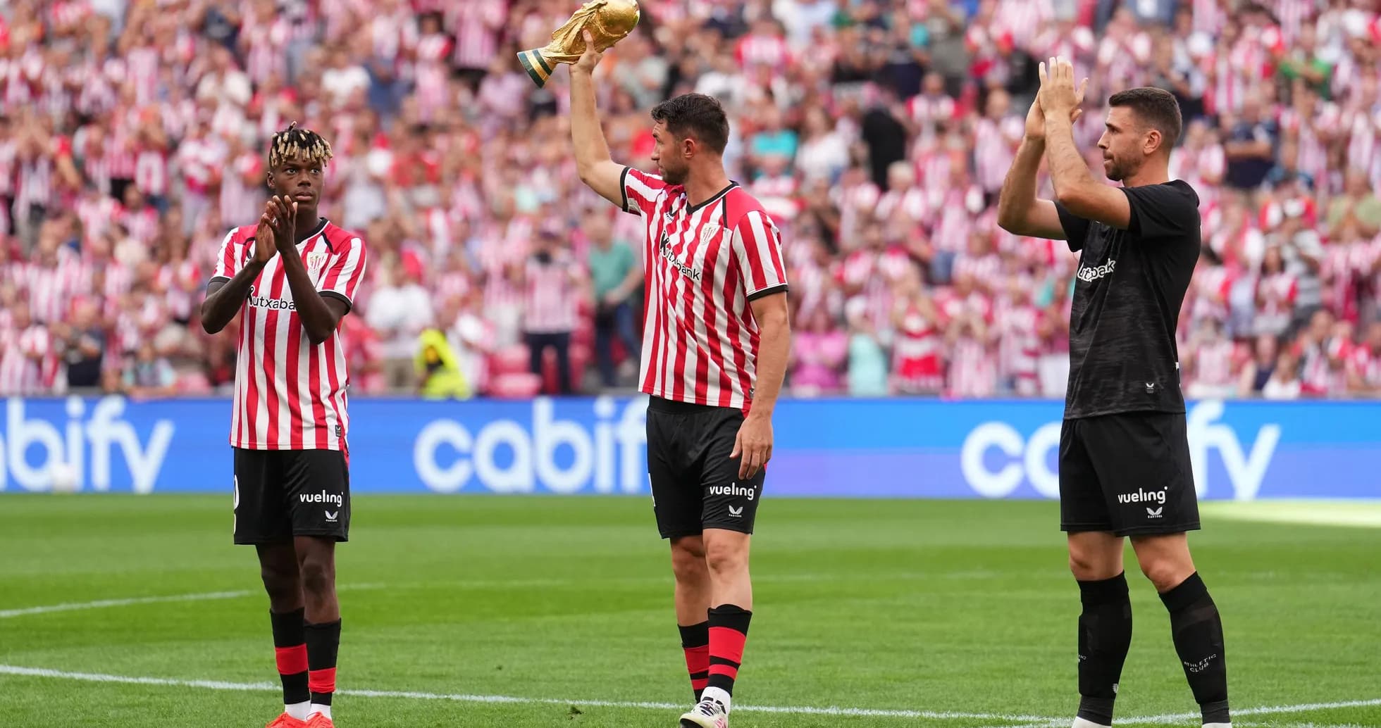 Jugadores de Athletic Club celebrando con trofeo en campo