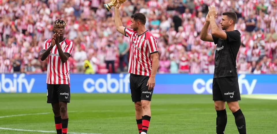 Jugadores de Athletic Club celebrando con trofeo en campo