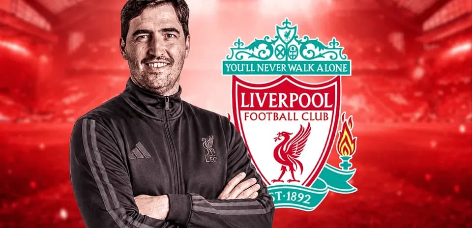 Entrenador posando frente al logo de Liverpool