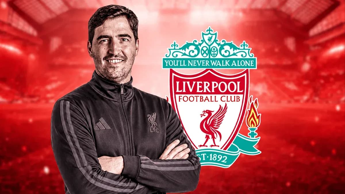 Entrenador posando frente al logo de Liverpool