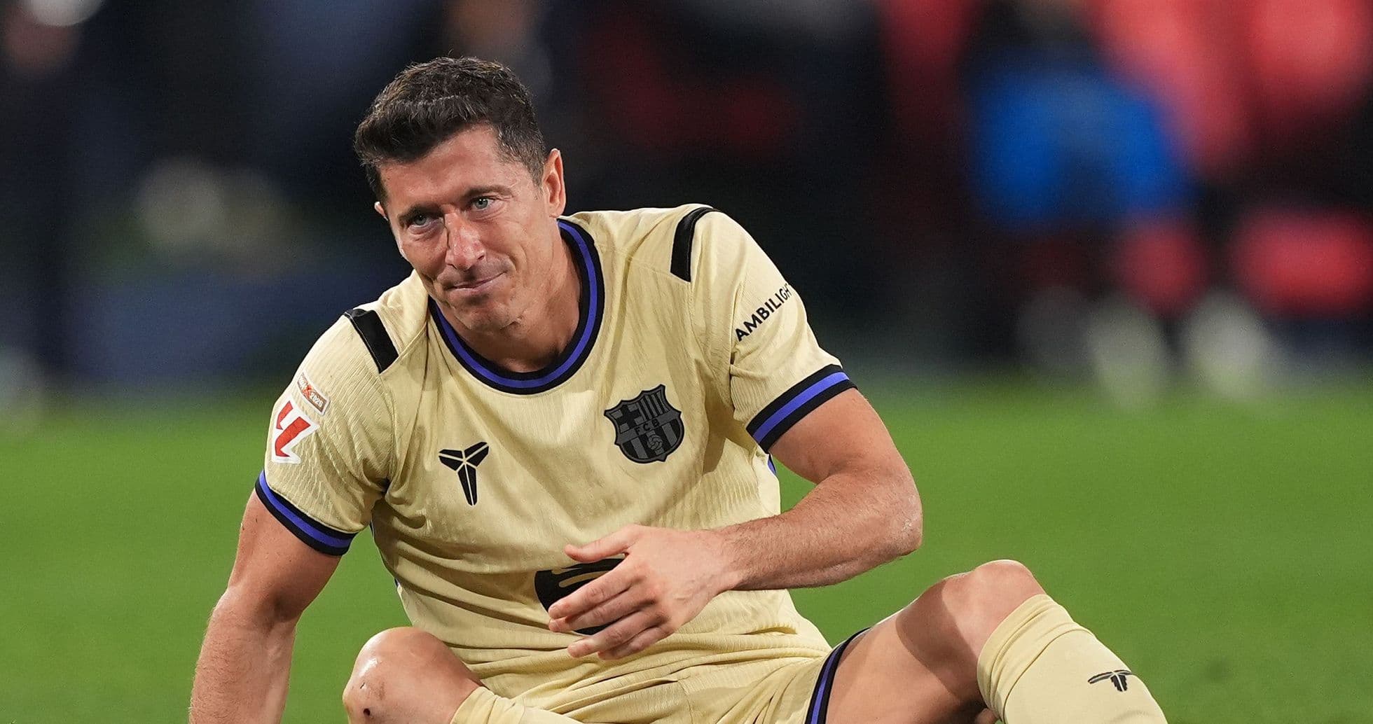 Jugador de fútbol sentado en el campo de juego