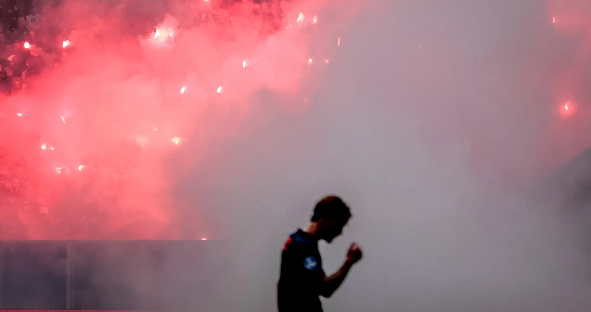 Jugador celebrando con humo y bengalas en fondo