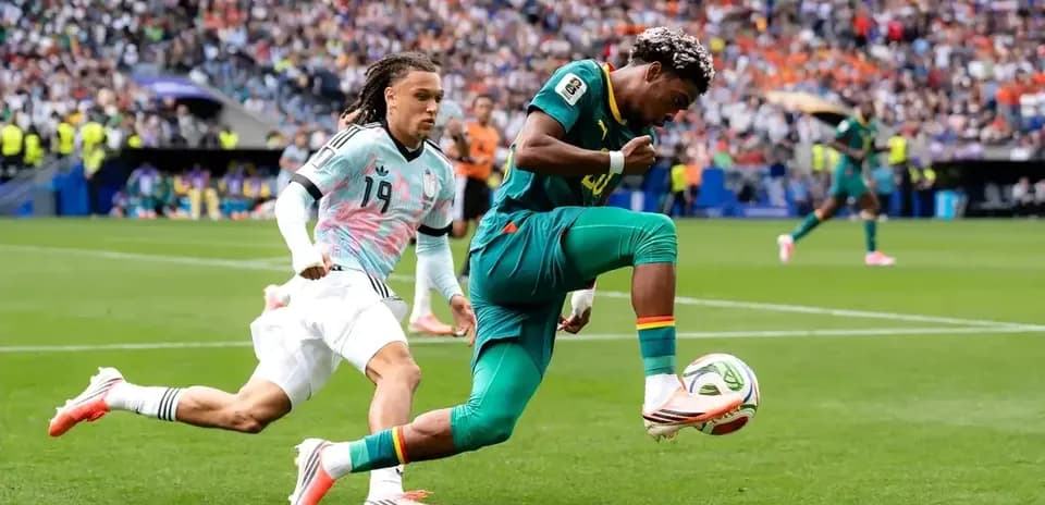 Jugador de Camerún driblando a defensor durante partido