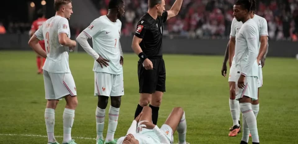 Jugadores de Francia observando a compañero caído