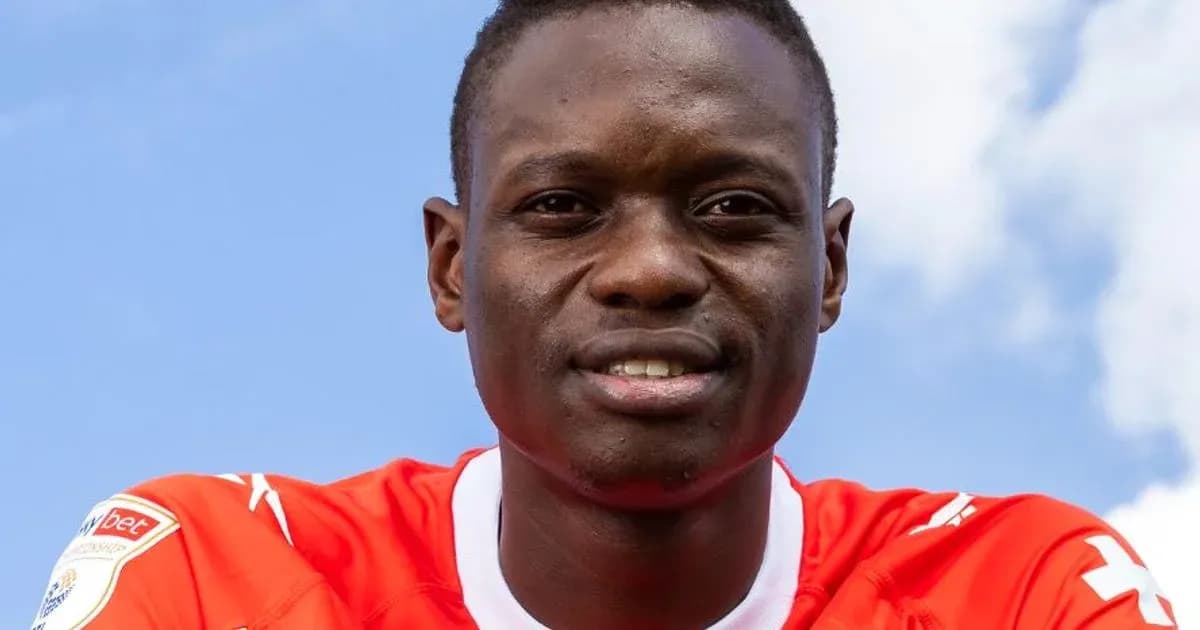 Jugador sonriendo con camiseta roja frente a cielo