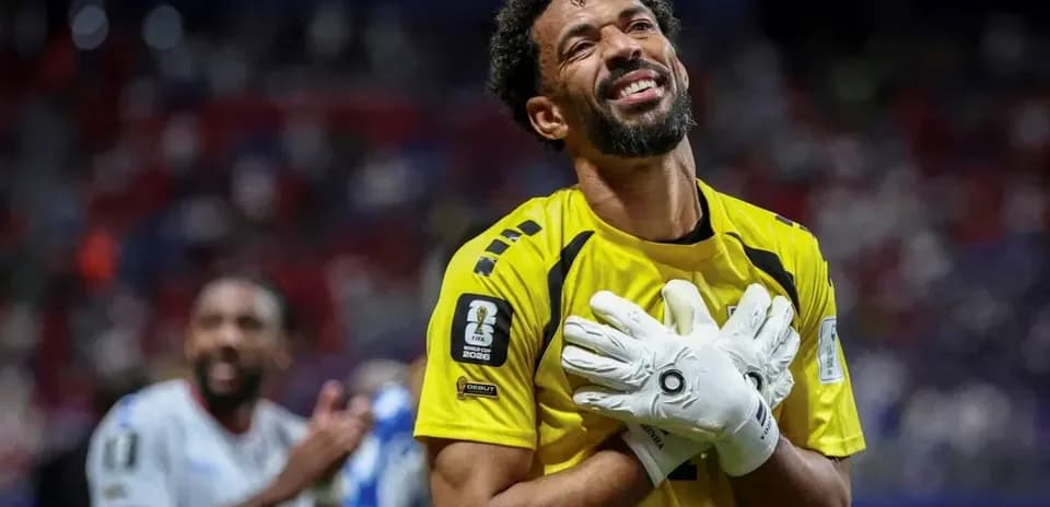 Portero sonriendo con guantes en el campo