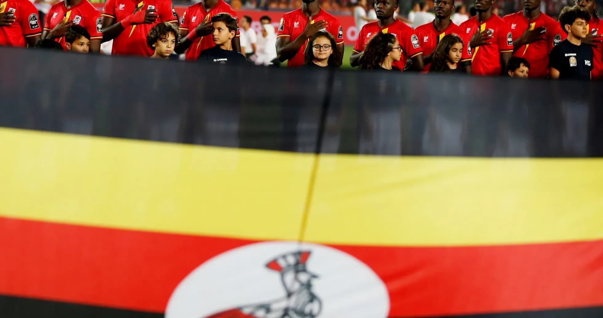 Jugadores de Uganda con bandera nacional en el estadio