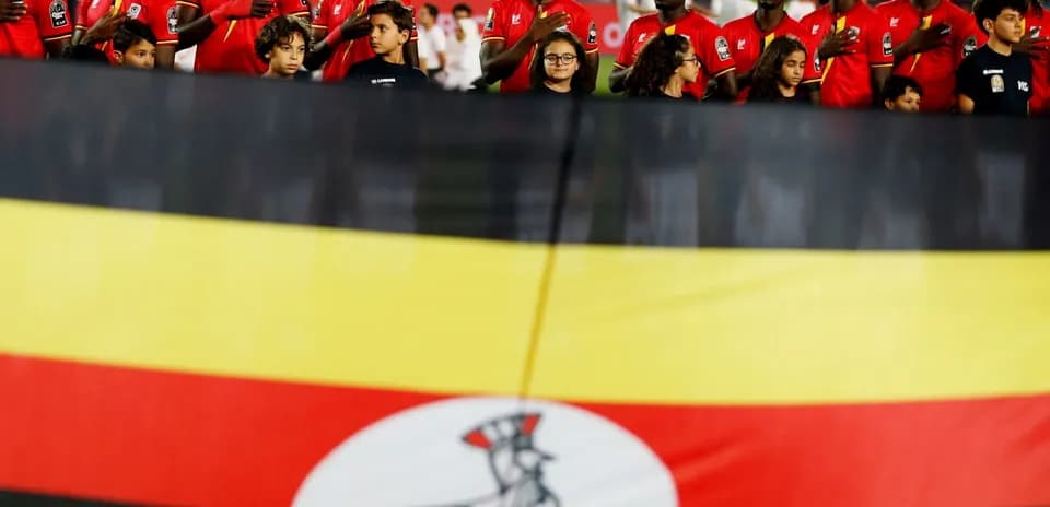 Jugadores de Uganda con bandera nacional en el estadio