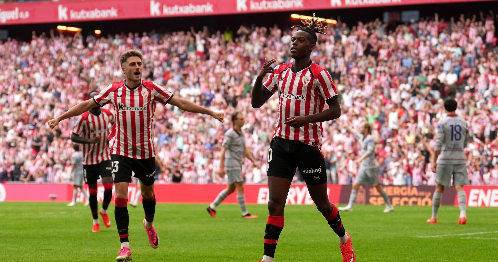 Jugador celebrando un gol con compañeros en estadio