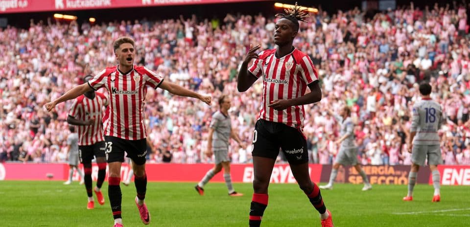 Jugador celebrando un gol con compañeros en estadio