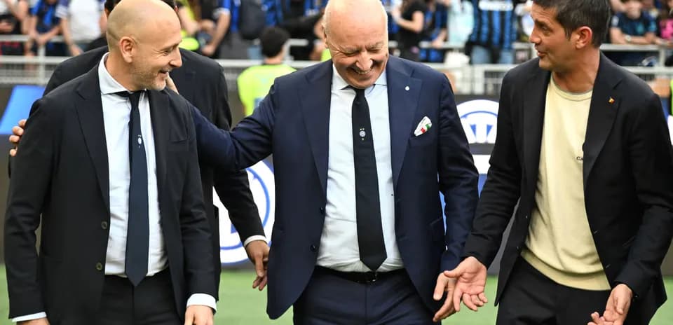 Tres entrenadores conversando en el campo de juego